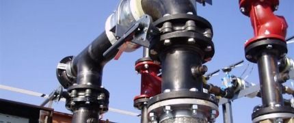 A close up of a bunch of pipes with a blue sky in the background