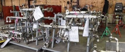 A bunch of pipes are sitting on a cart in a factory.