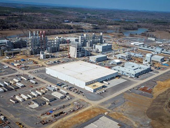 An aerial view of a large industrial area with a large white building in the middle.