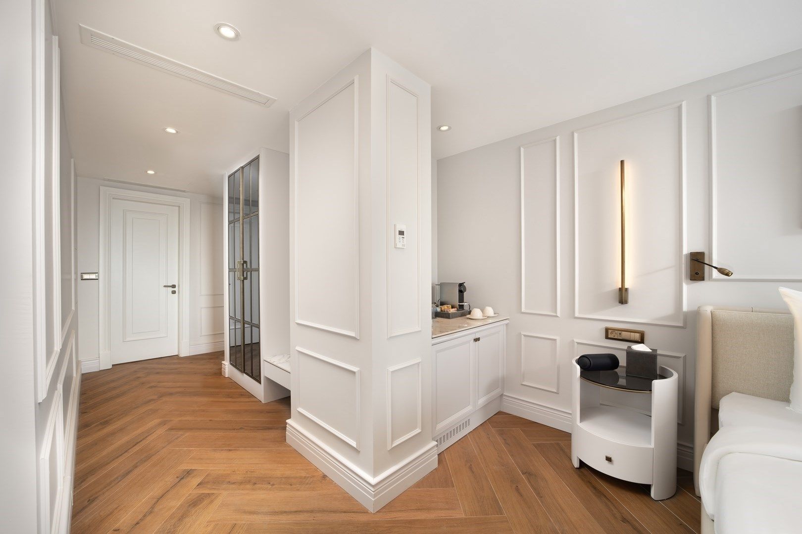 Mula Hotel | A bright hotel room with white walls, wood floors, and a built-in cabinet.