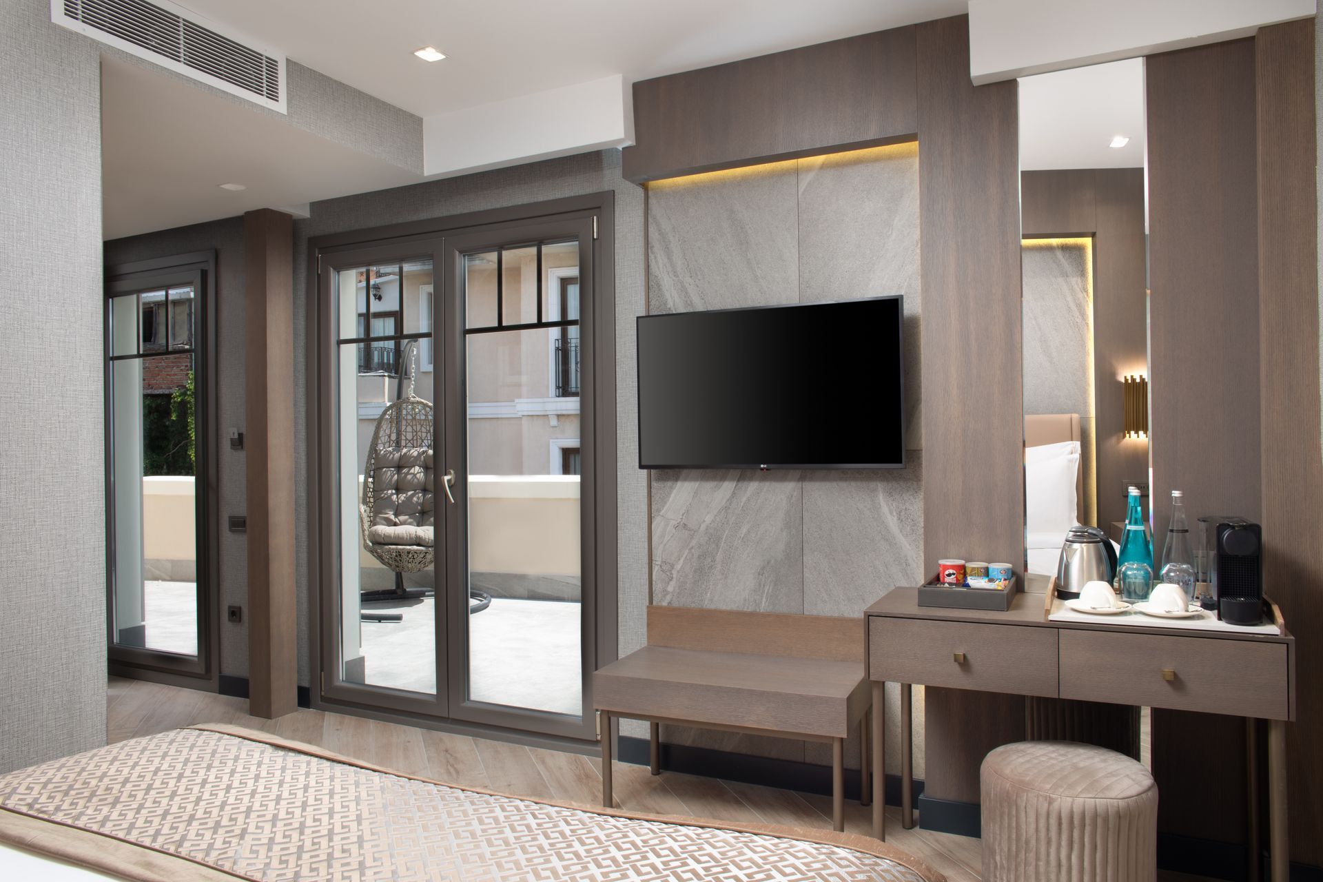 Mula Hotel | Hotel room with a balcony, TV, and desk. Neutral tones, modern decor.