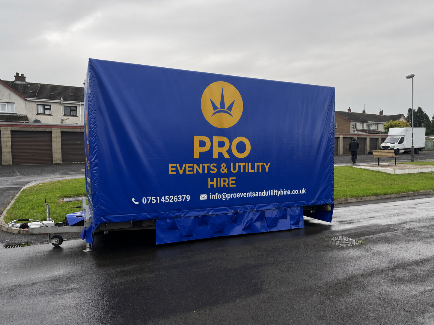 Blue trailer with PRO Events & Utility Hire branding parked on a wet street.