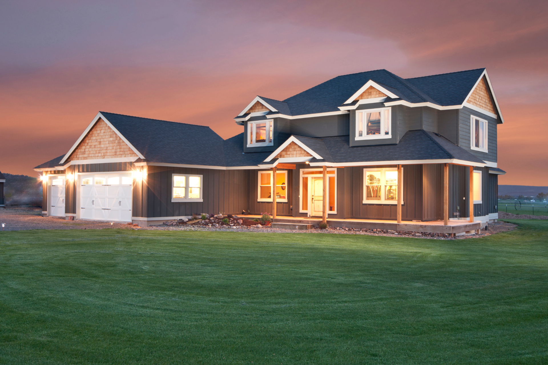 A large custom home with a lot of windows is lit up at night