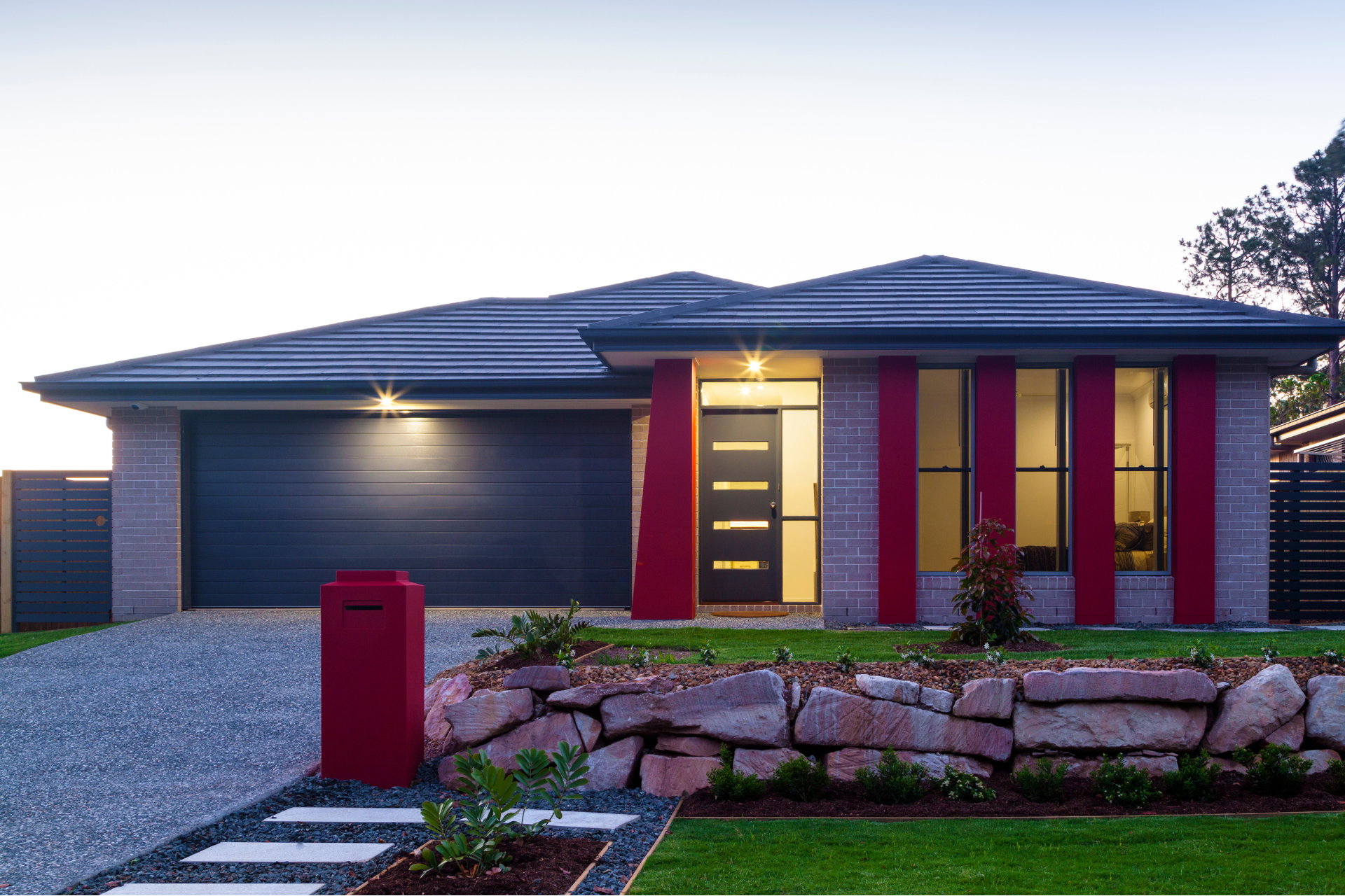 A custom home with a red mailbox in front of it
