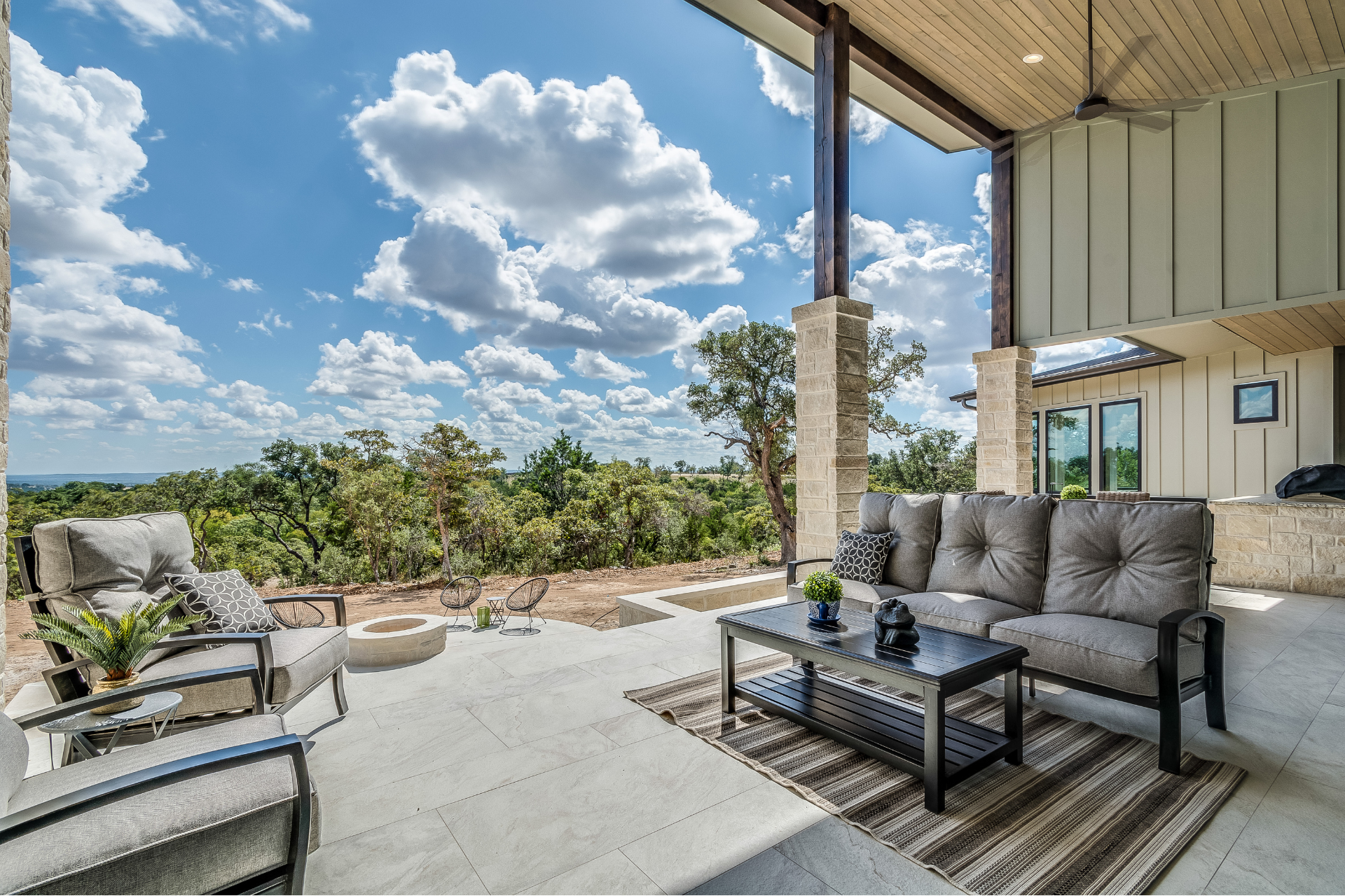 A beautiful view from a patio with a couch, chairs, and a coffee table.