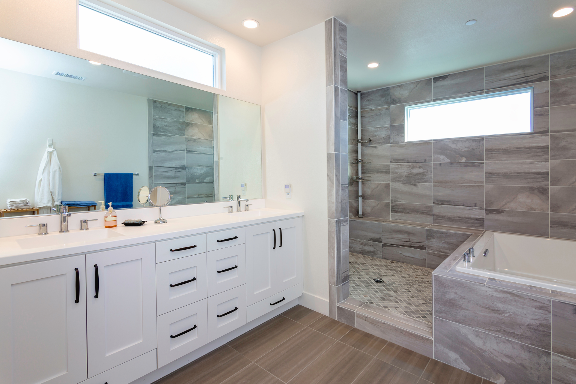 A bathroom with two sinks, a tub and a walk-in shower.