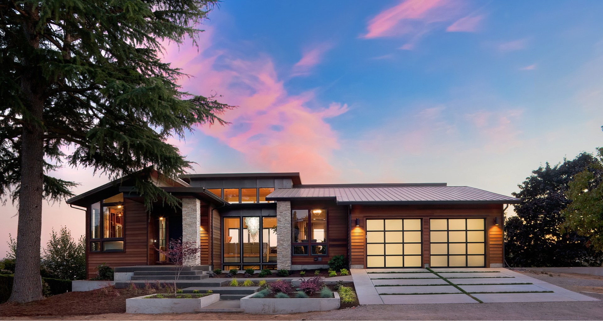 A modern custom home with a purple sky in the background