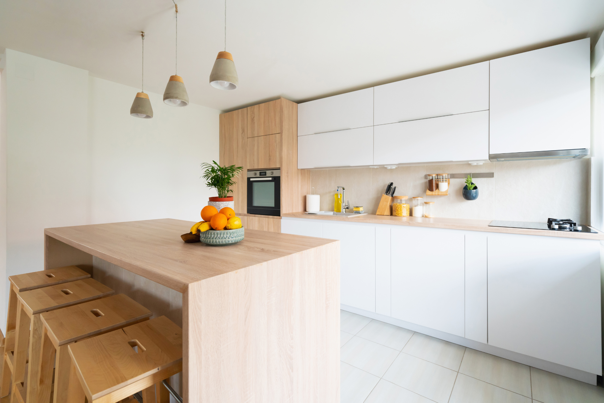 A kitchen with white cabinets and wooden counter tops and stools.