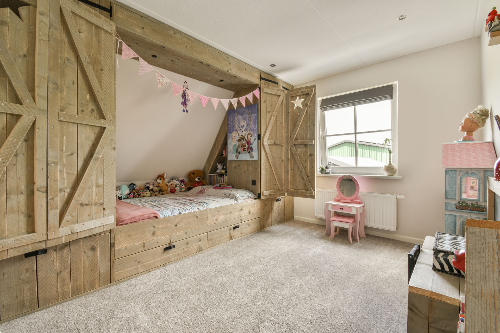 A child 's bedroom with a wooden bed and a pink vanity.
