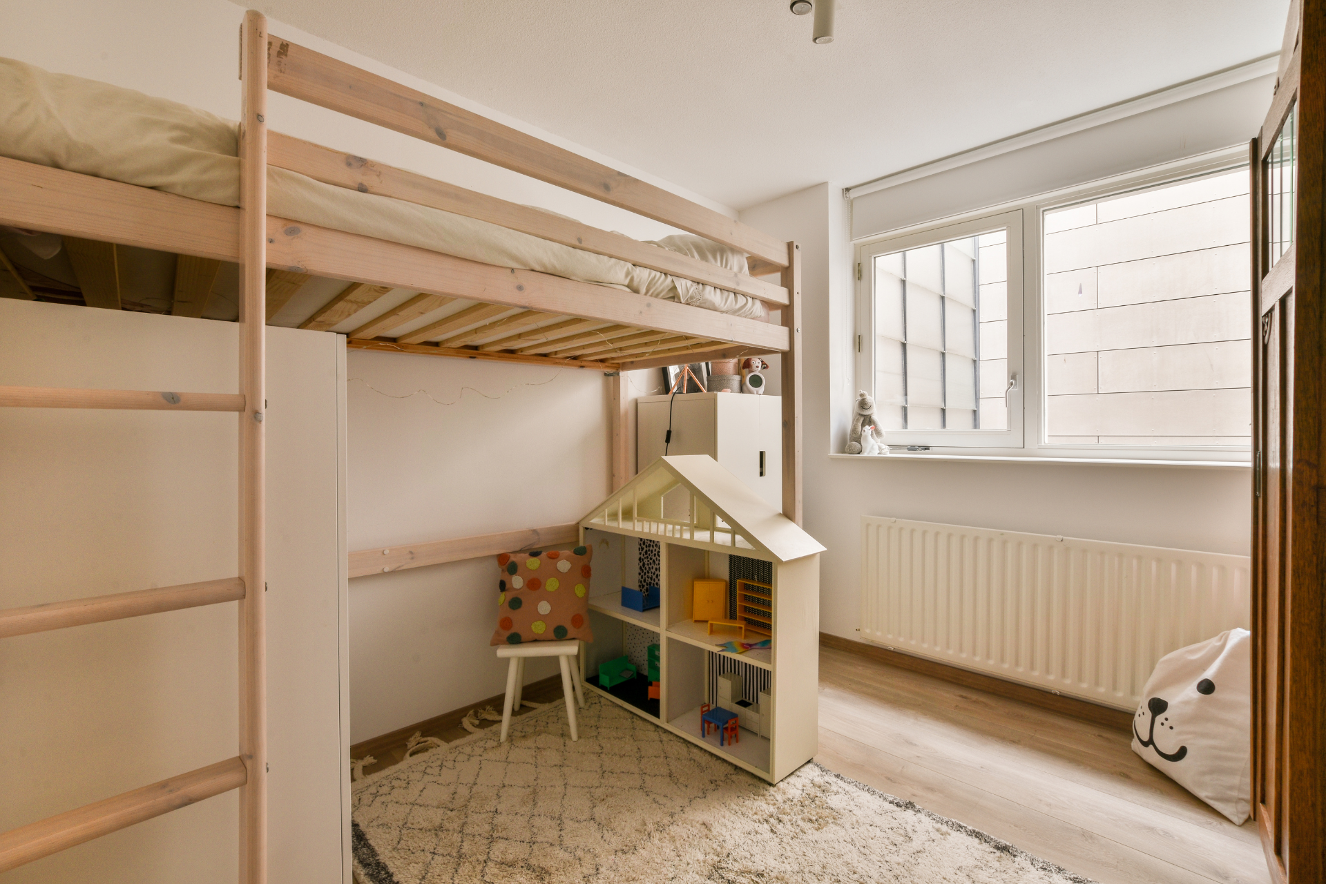 A bedroom with a bunk bed and a doll house.