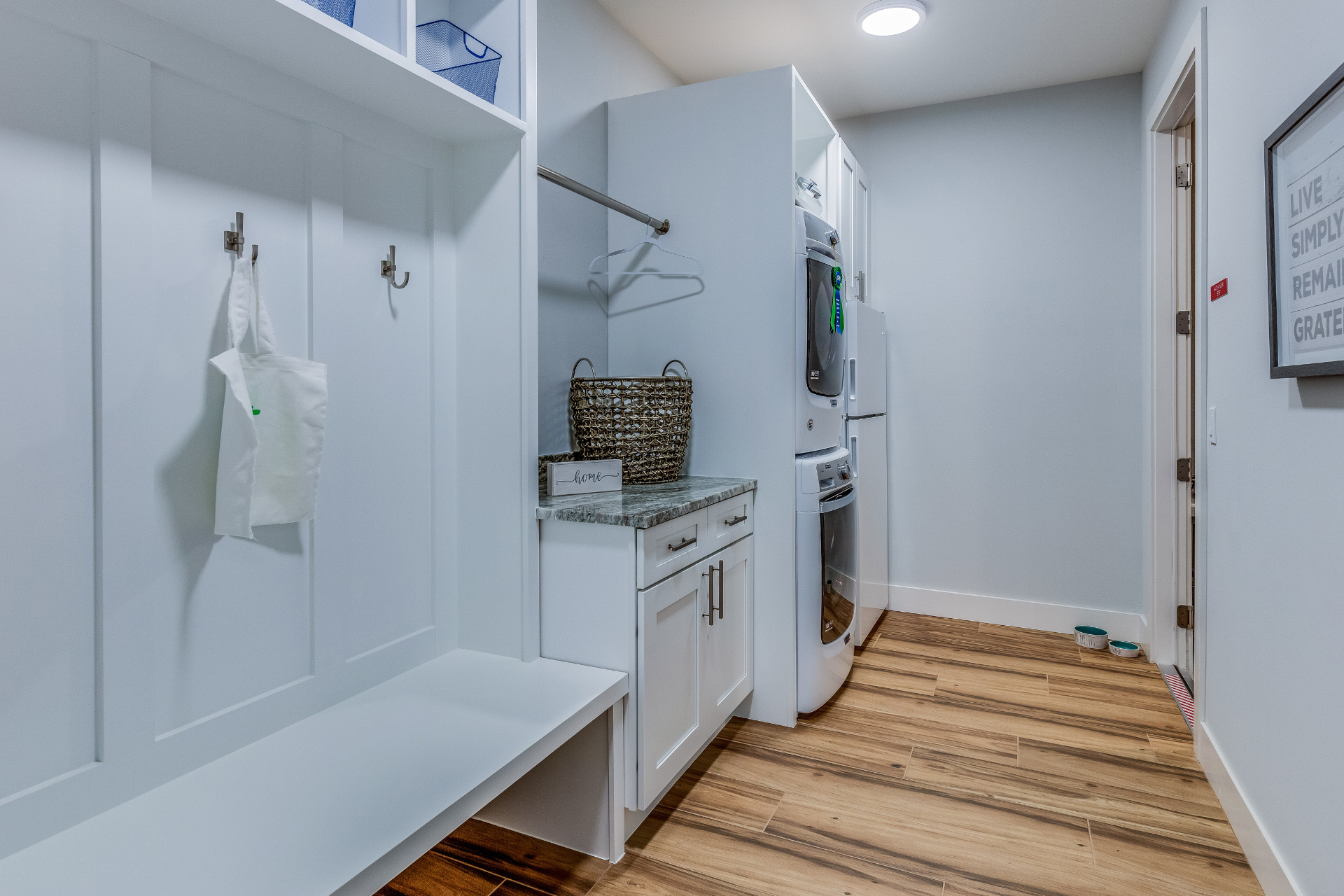 A laundry room with a washer and dryer , a bench , and a rug.