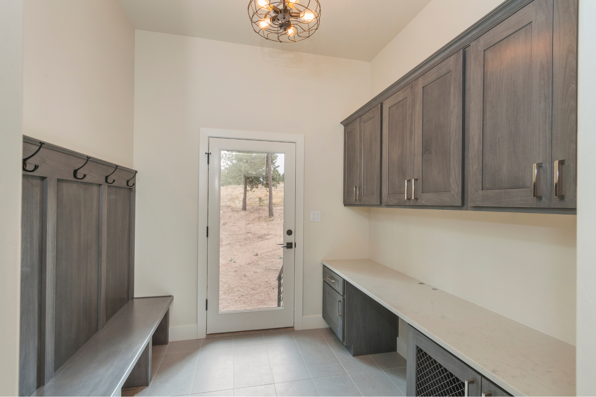 A mud room with a bench , cabinets , and a door.