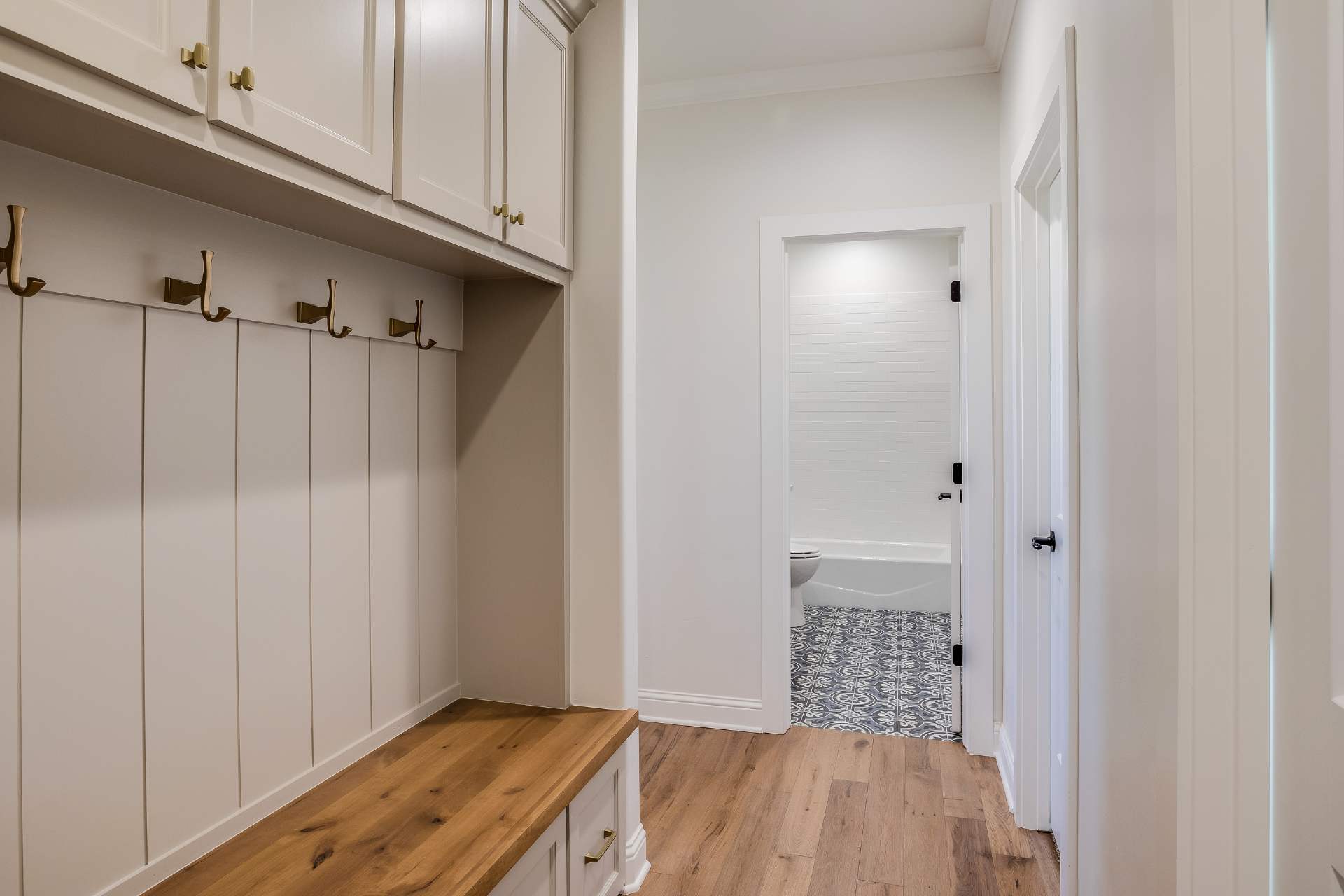 A mudroom with a wooden bench and hooks on the wall.