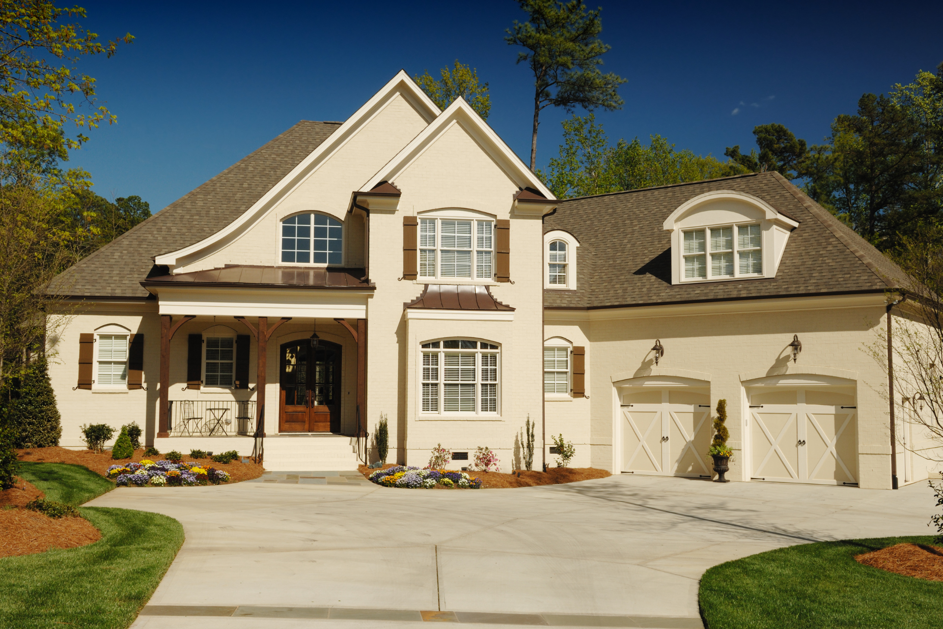 A large white custom home with two garages and a driveway