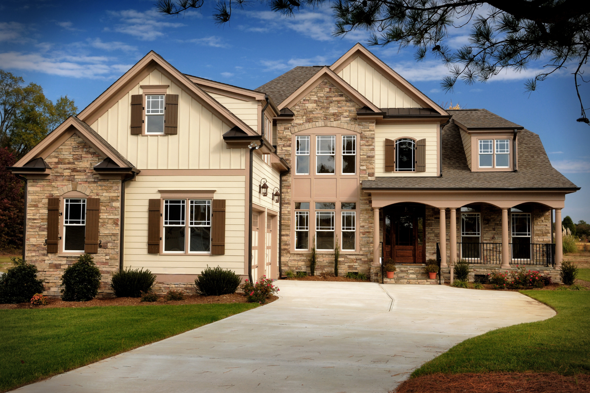 A large custom home with a lot of windows and a driveway