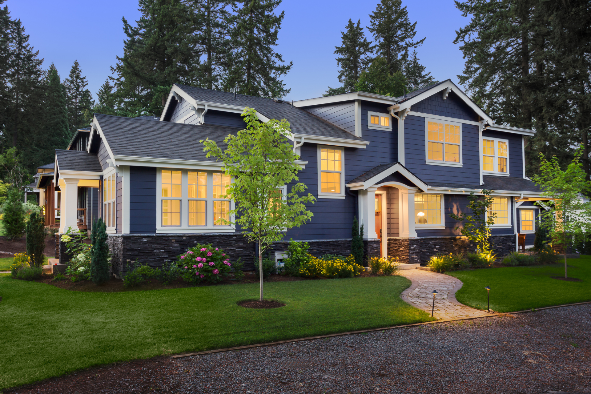 A large blue and white custom home with lots of windows