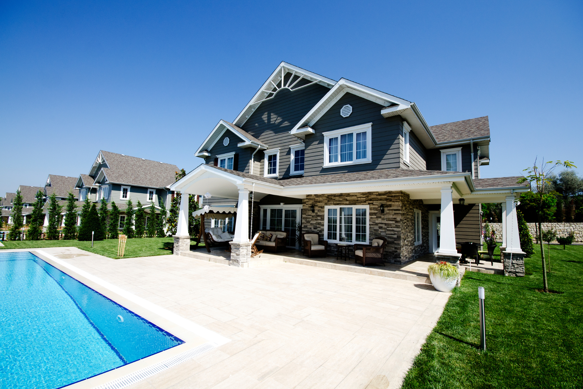 A large custom home with a swimming pool in front of it