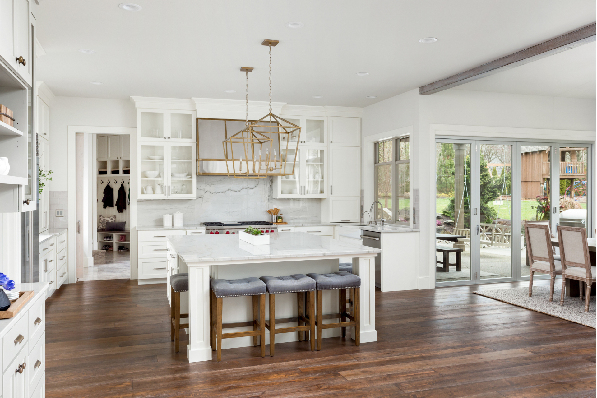 A kitchen in a new custom home with white cabinets and hardwood floors.