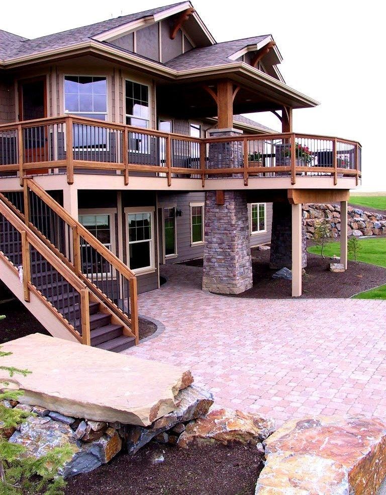A large custom home with a large deck and stairs