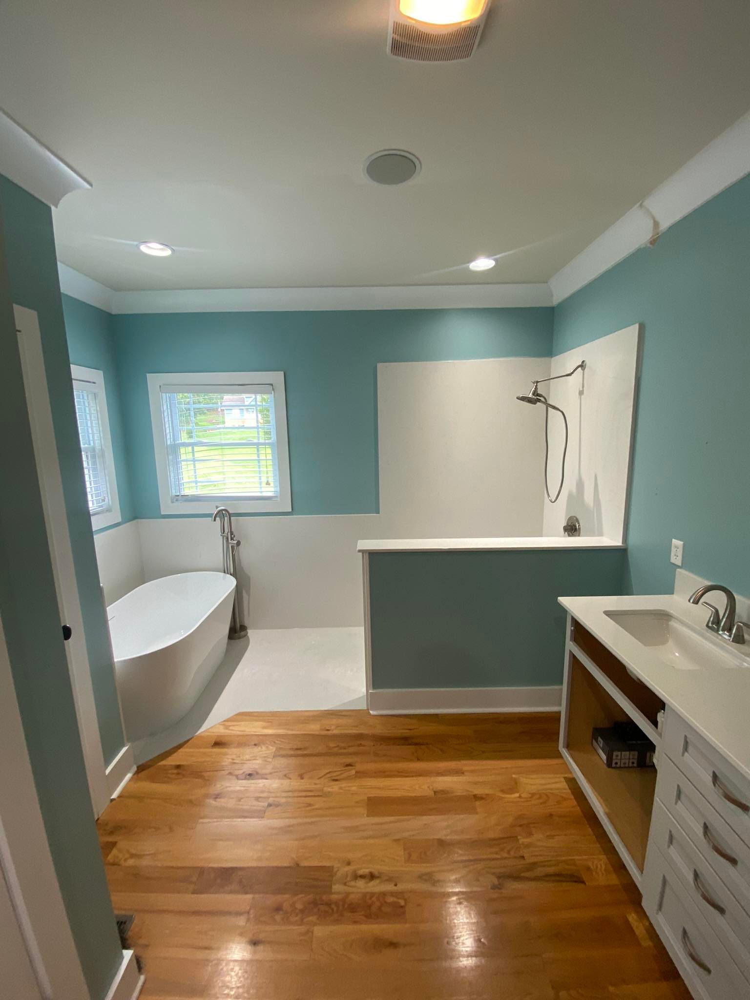 A bathroom with a tub , sink , and shower.