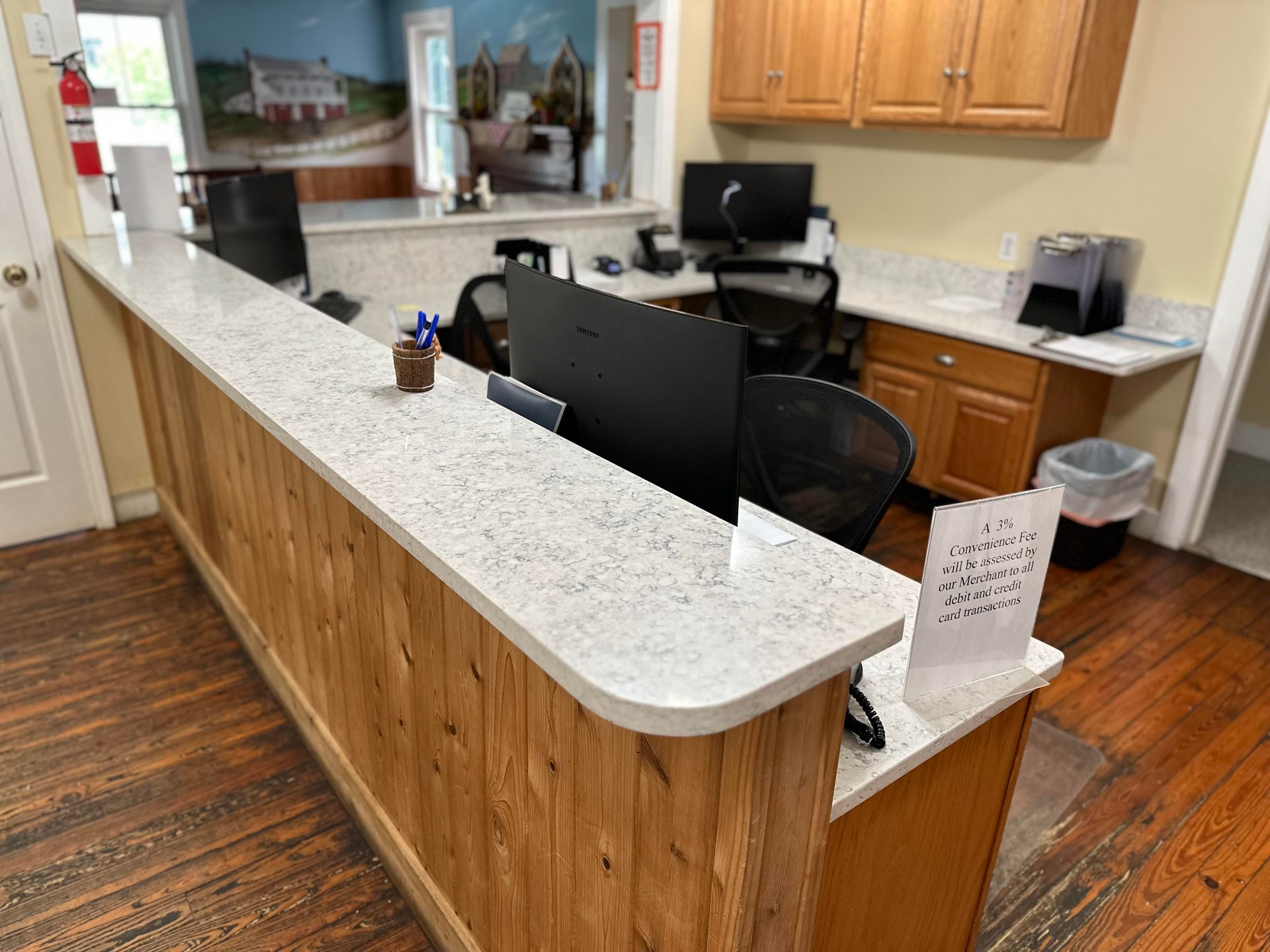 A long wooden counter with a computer on it in a dental office.