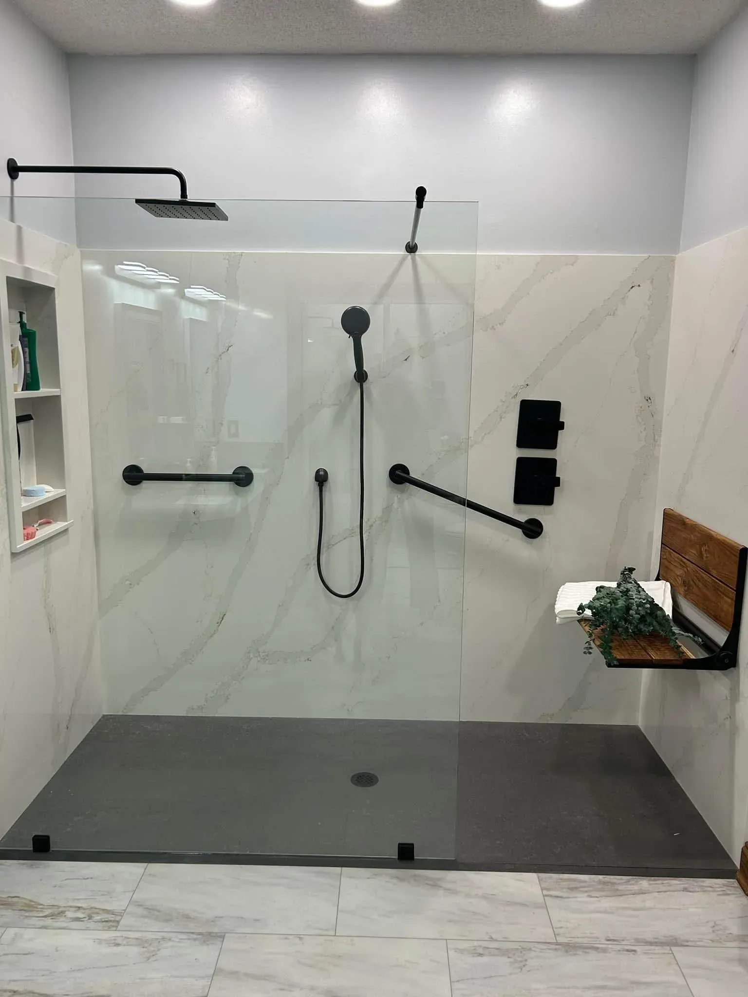 A bathroom with a walk in shower and a bench.