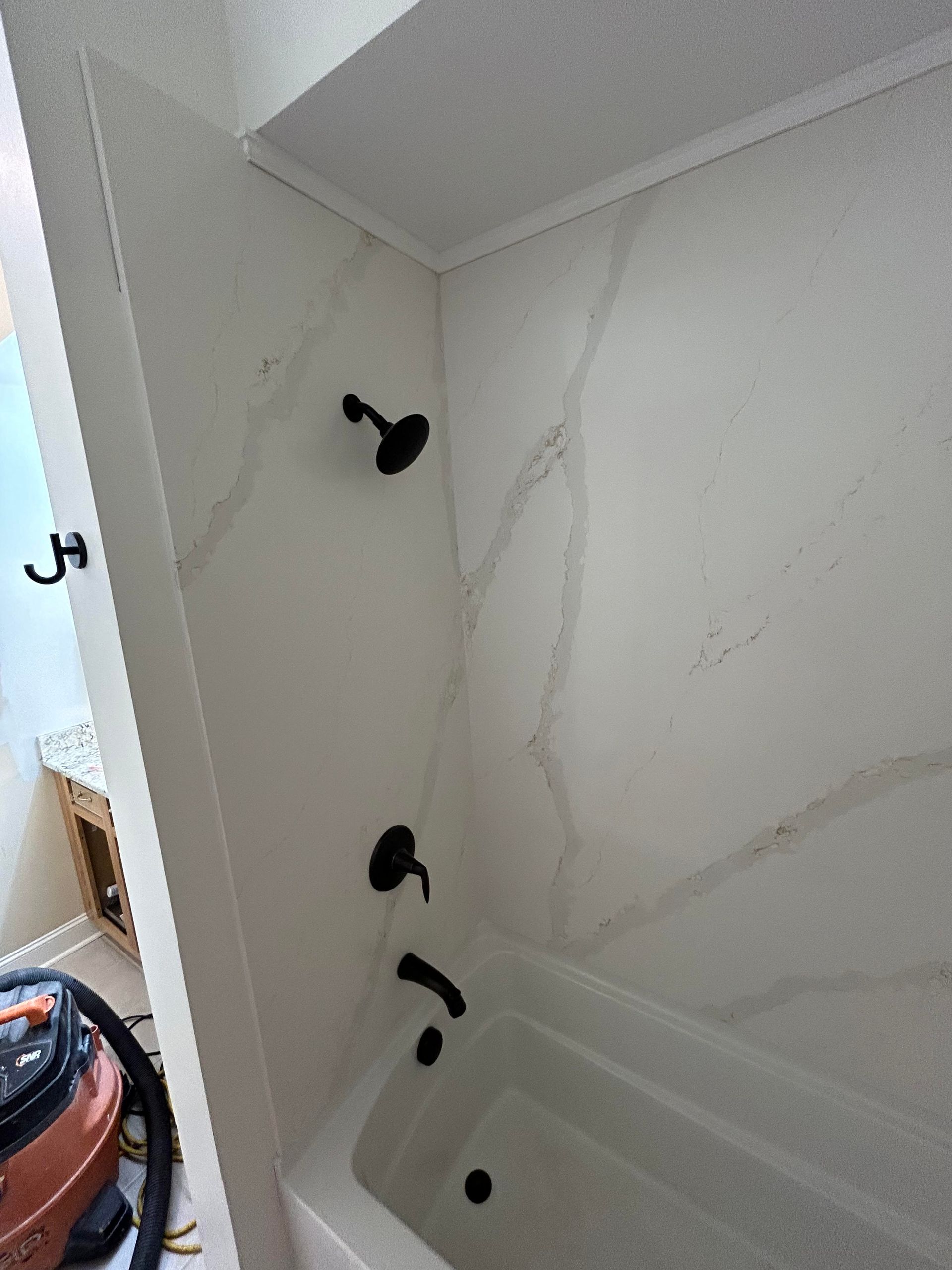 A bathroom with a bathtub and a shower head.