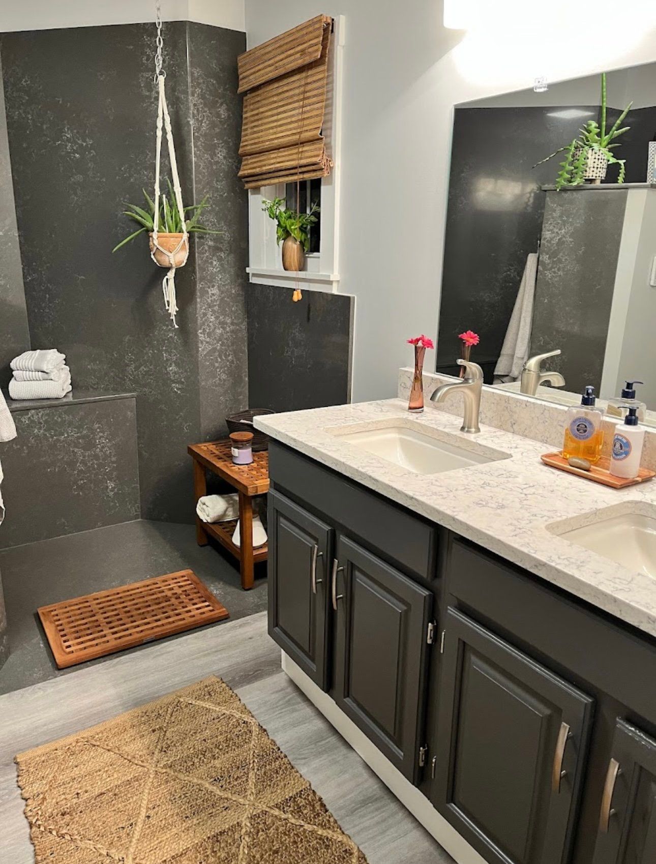 A bathroom with two sinks and a walk in shower.