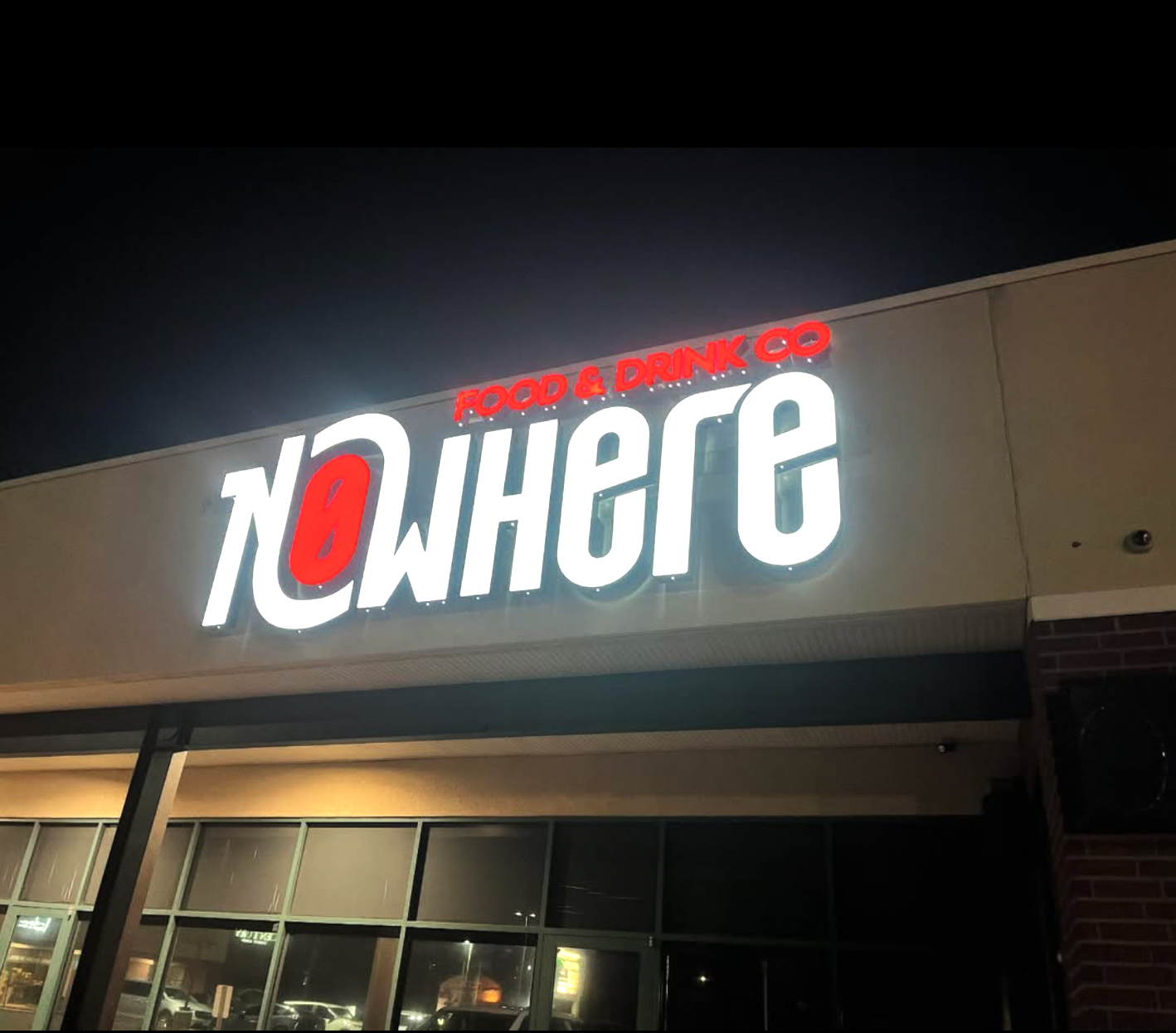 A sign for nowhere is lit up at night
