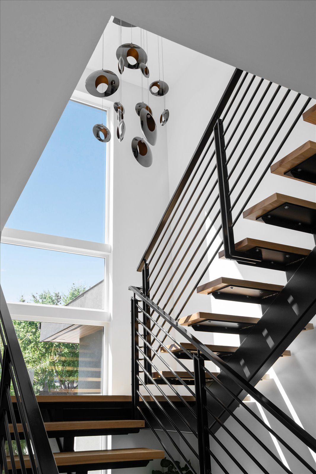 A modern staircase with a black railing and wooden steps
