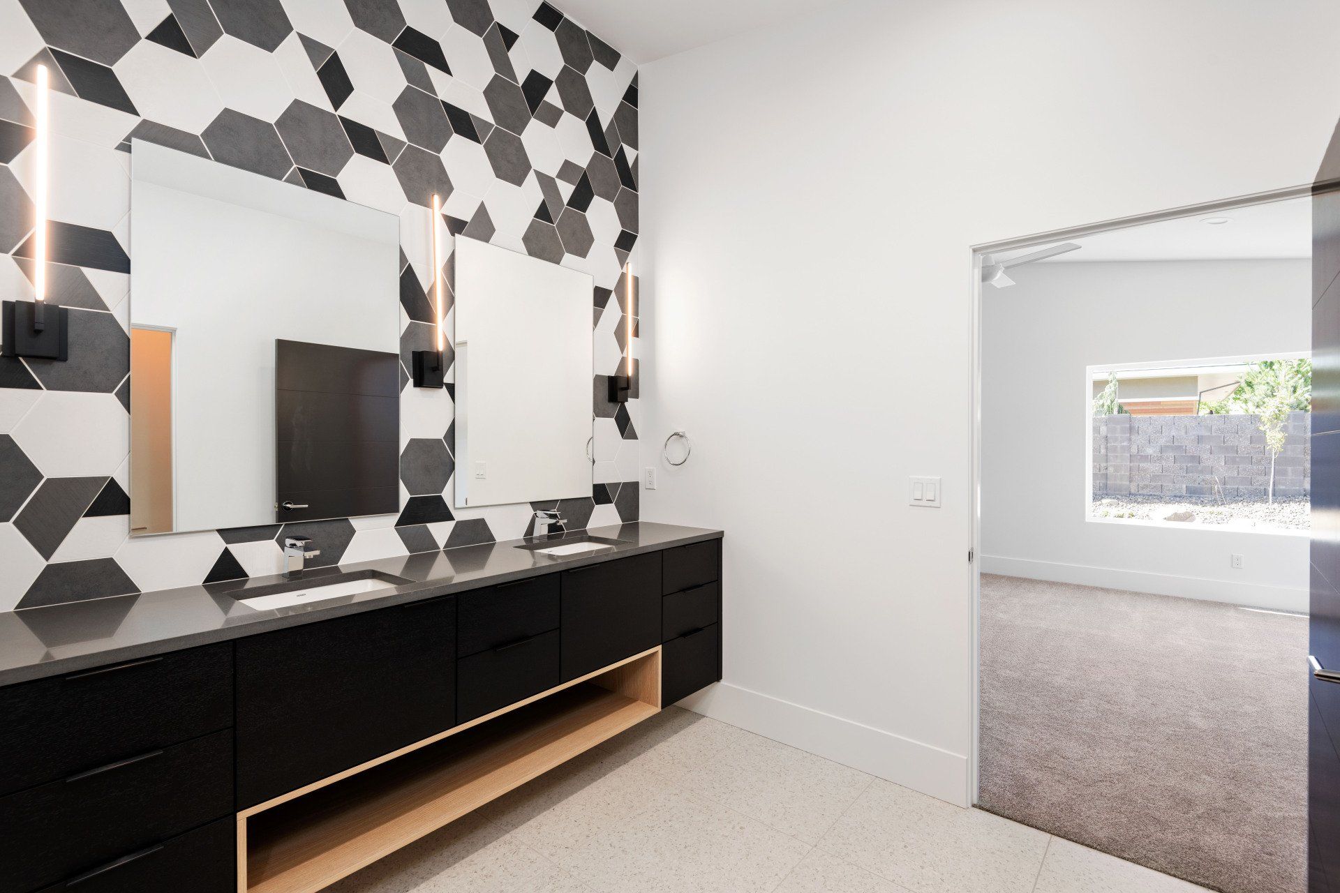 A bathroom with two sinks and a television on the wall.