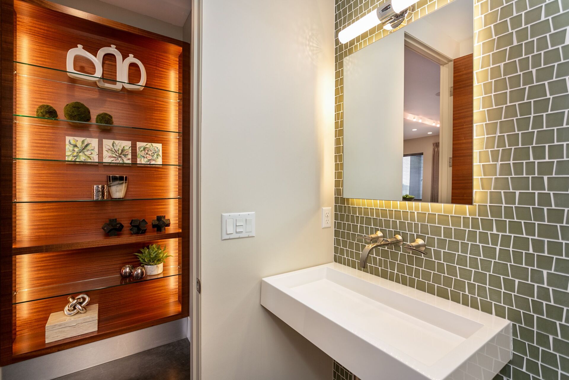 A bathroom with a sink , mirror and shelves.