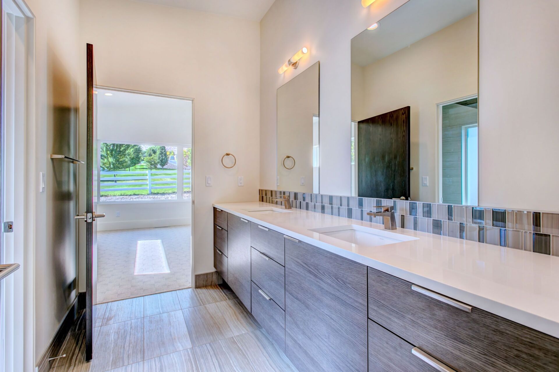 A bathroom with two sinks and a large mirror.