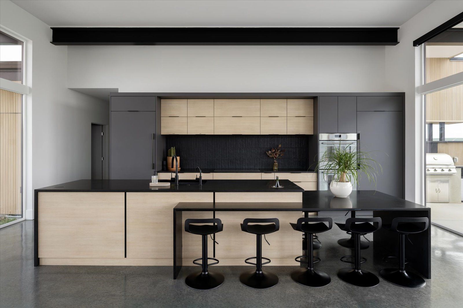 A modern staircase with a black railing and wooden steps