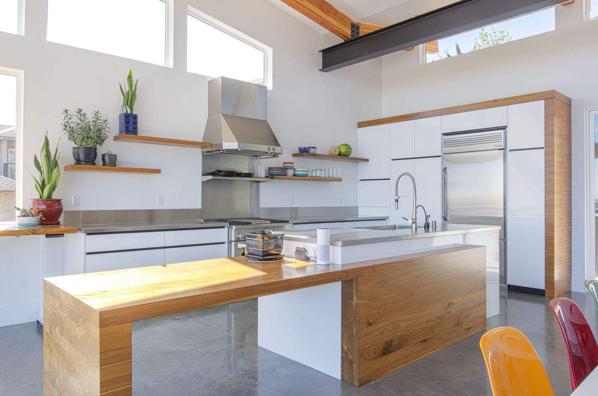 A kitchen with white cabinets , stainless steel appliances , and a wooden island.