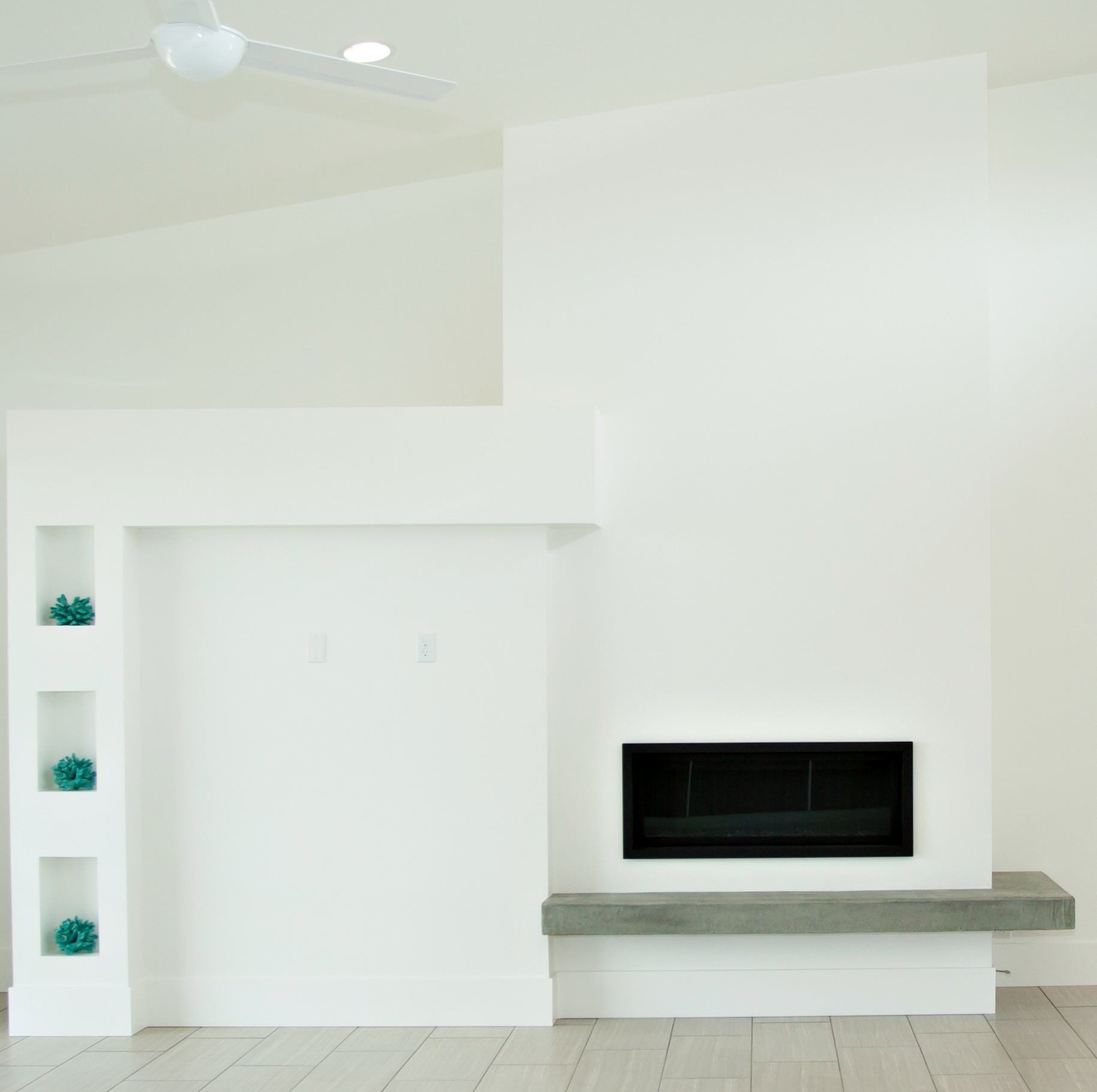 A living room with a fireplace and a ceiling fan