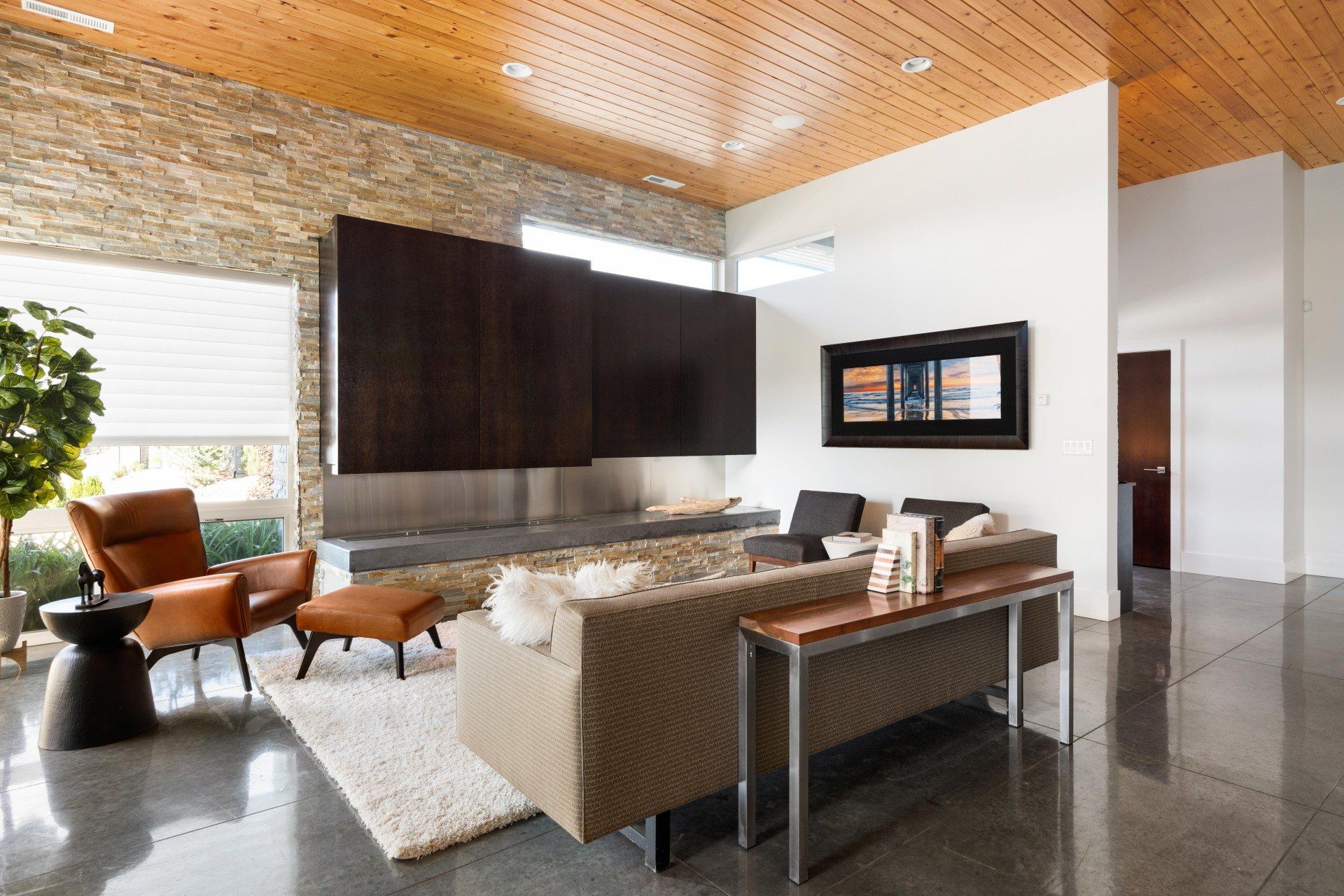 A living room with a couch , chair , table and fireplace.