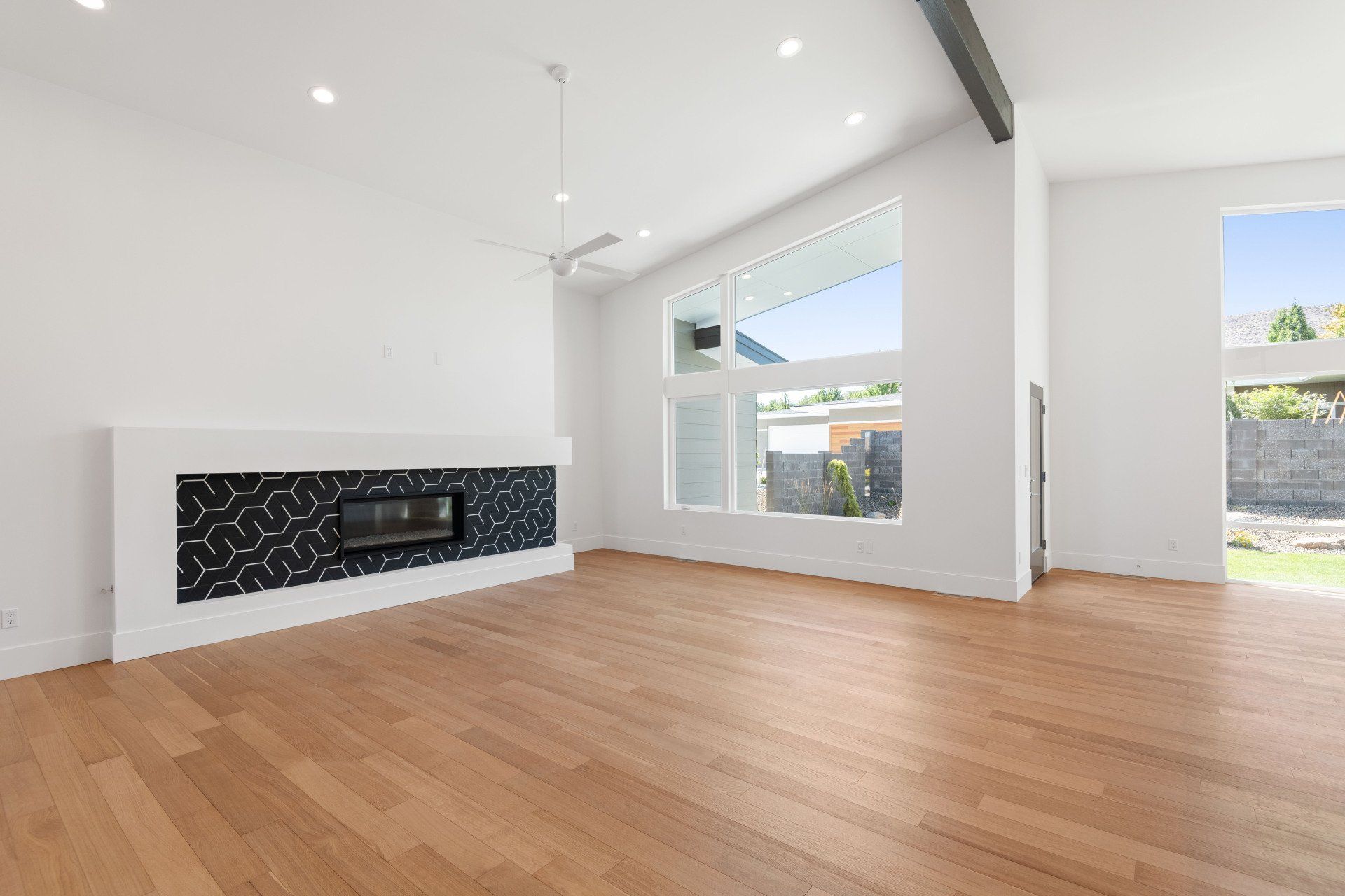 An empty living room with hardwood floors and a fireplace.