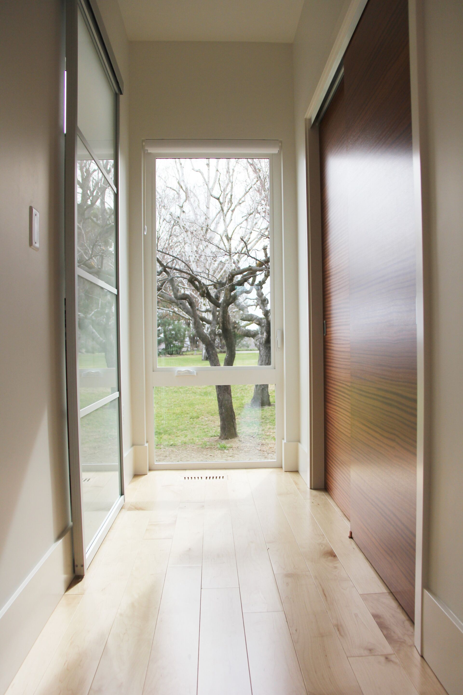 A hallway with a large window and trees in the background