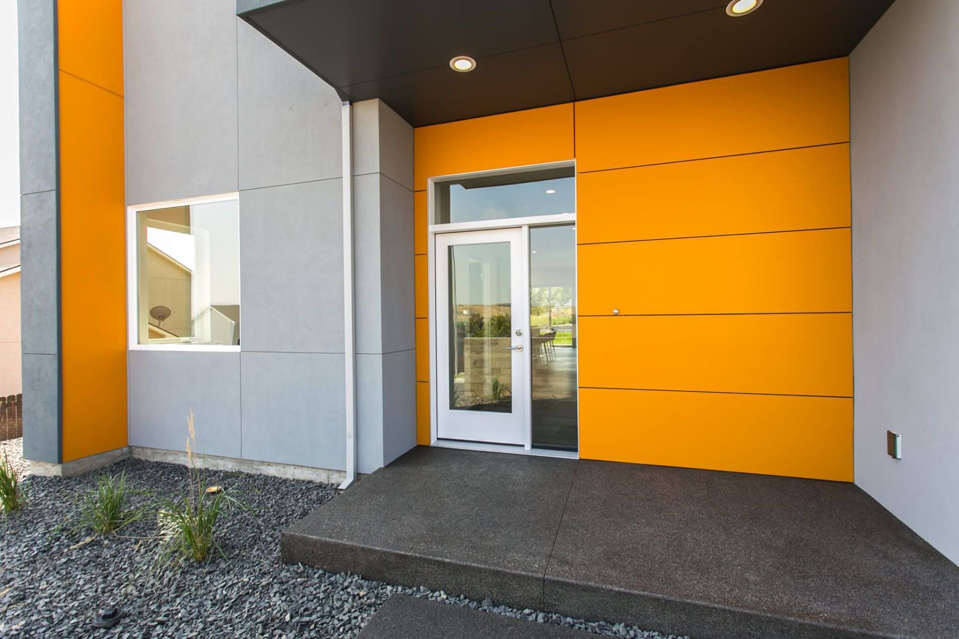 A yellow and gray building with a white door