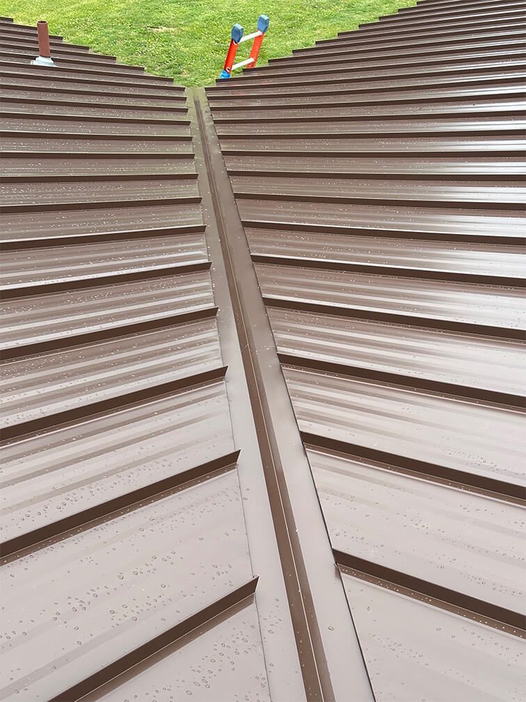 A close up of a brown metal roof with a gutter.