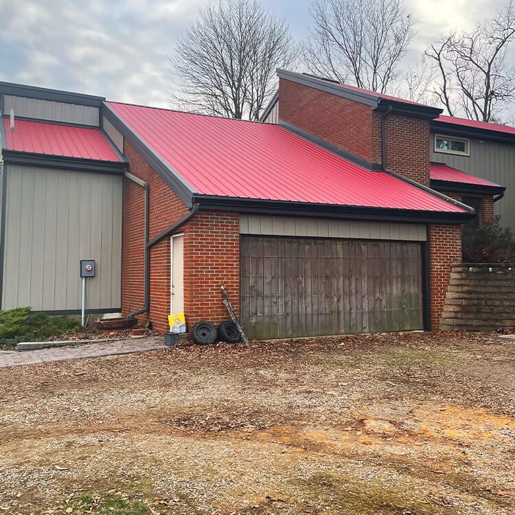 A close up of a roof with a lot of shingles and trees in the background.