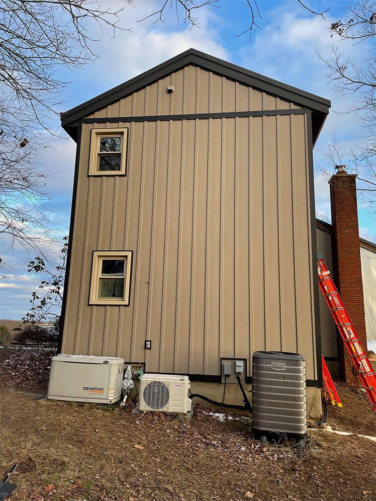 A house with a generator and air conditioner on the side of it.
