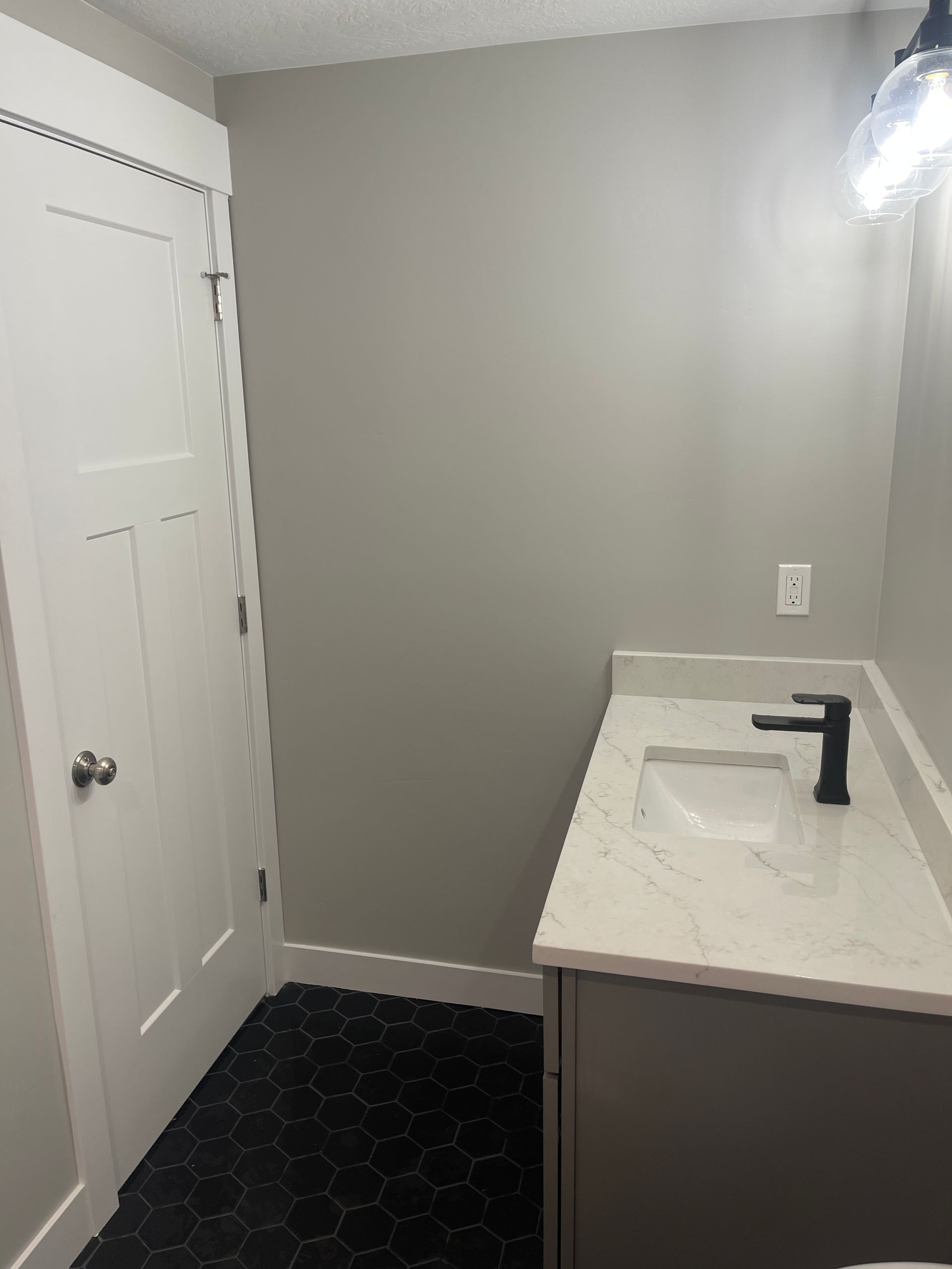 A bathroom with a sink , toilet , and door.