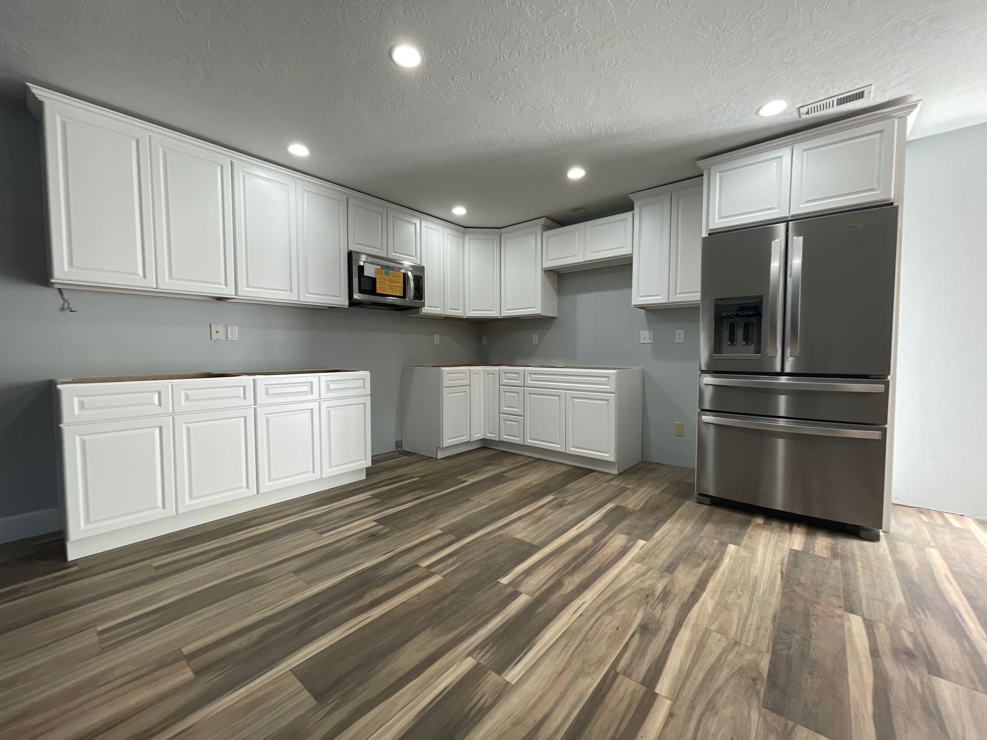 A kitchen with white cabinets and stainless steel appliances.