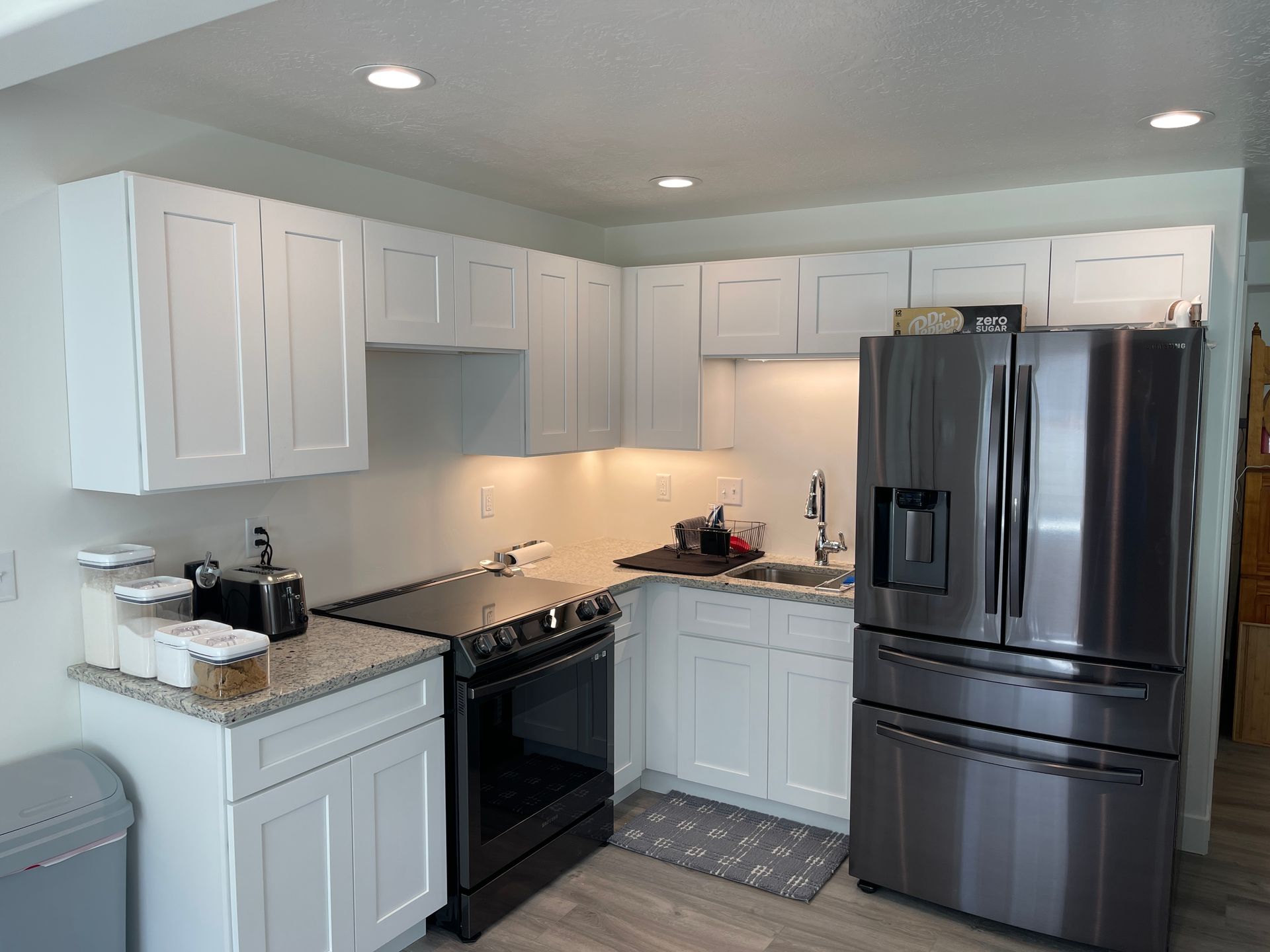 A kitchen with stainless steel appliances and white cabinets.