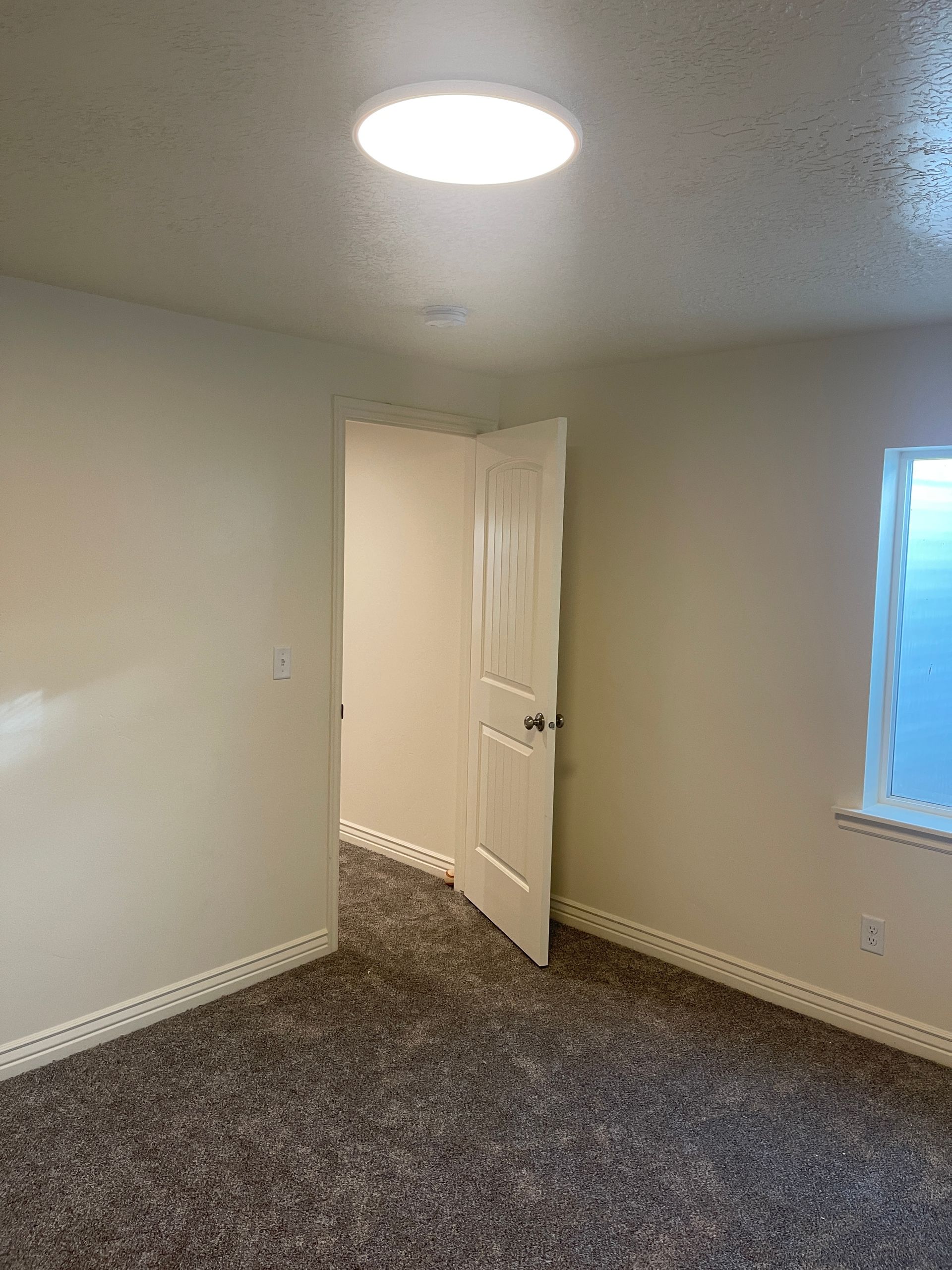 An empty room with a door and a window.