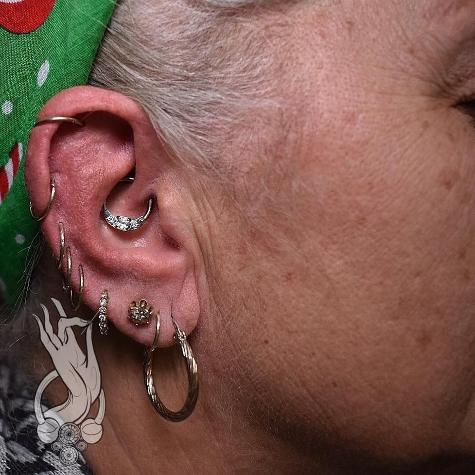 a close up of a woman 's ear with a lot of piercings .