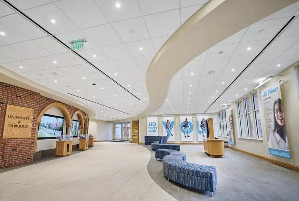 A large lobby with a curved ceiling and a brick wall.