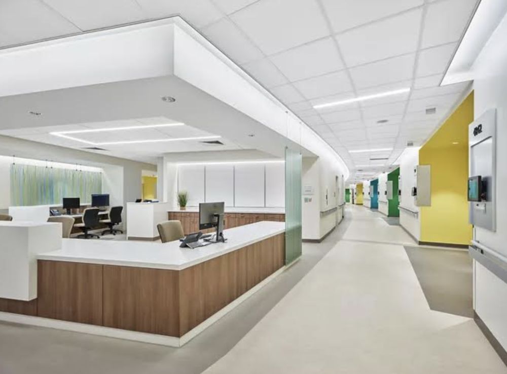 A hospital hallway with a nurse 's station and a computer desk.